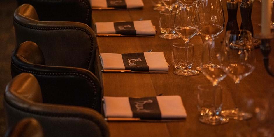 long table laid with napkins and wine glasses