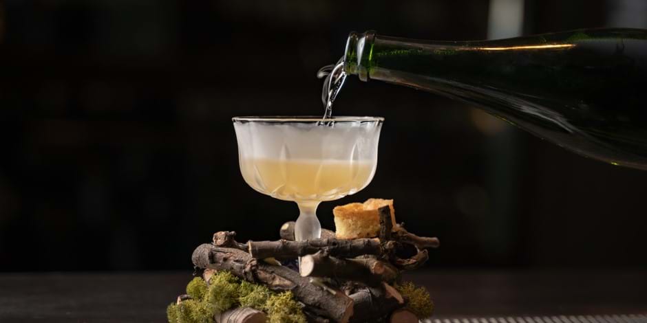 pouring drink into frosted glass with logs decor